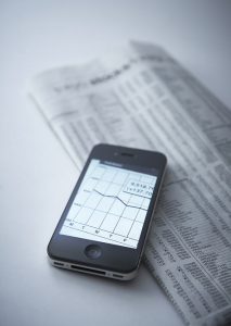 stock performance -phone and newspaper